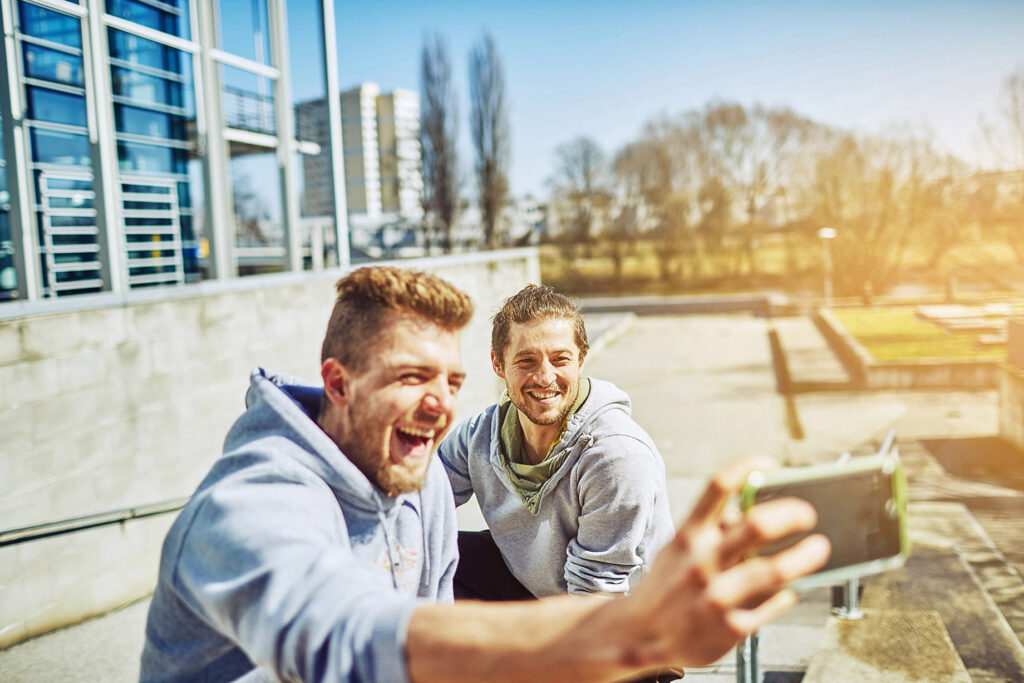 Streetrunner wird mit dem Smartphone beim Sprung über ein Geländer gefilmt – actionreiche Szene einer urbanen Lifestyle-Kampagne von Atelier Schulte.
