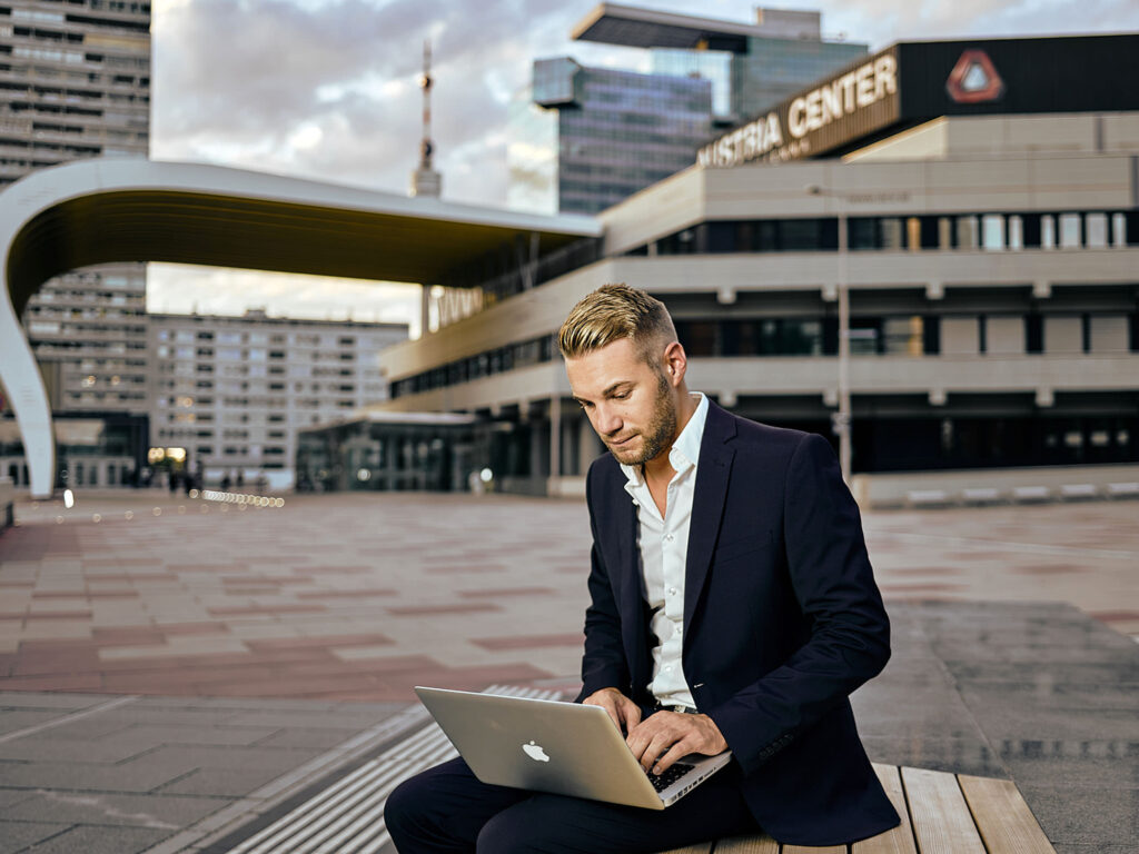 Professionelles Businessportrait vor Glasfassade und Skyline in Wien – Corporate Fotografie von Atelier Schulte, spezialisiert auf urbane Businessbilder.
