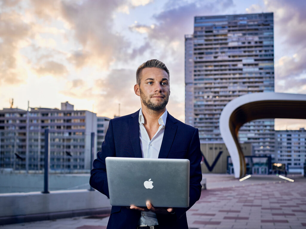 Businessfoto bei Abendlicht mit Laptop vor dem Austria Center Vienna – authentische Businessfotografie von Atelier Schulte für Unternehmen und Selbständige.