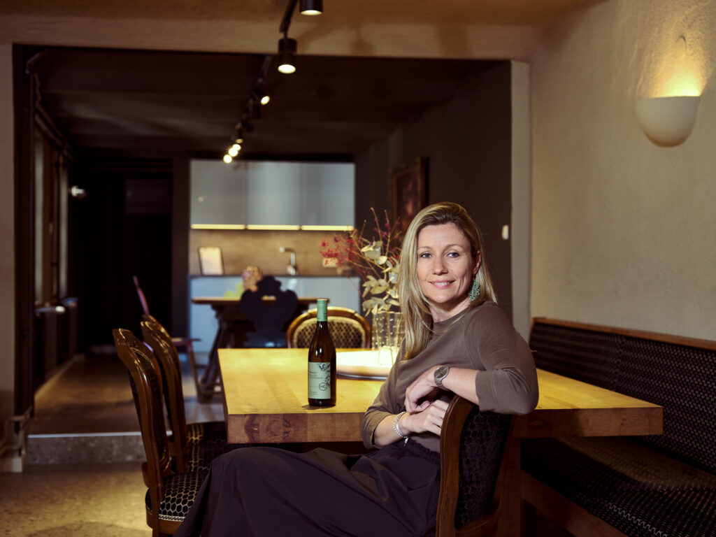 Businessportrait einer Winzerin am Eingang des Weinguts, fotografiert von Atelier Schulte, spezialisiert auf Business- und Unternehmensfotografie.