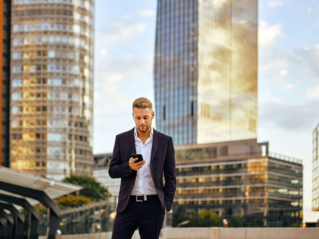 Businessfotografie in Wien – junger Unternehmer mit Smartphone und Laptop am Austria Center Vienna, fotografiert von Atelier Schulte.