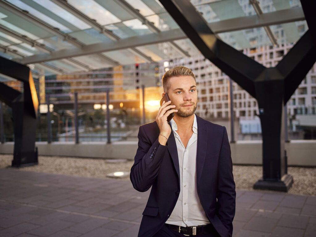 Businessportrait mit Handygespräch bei Sonnenuntergang – moderne Corporate Fotografie in urbaner Umgebung von Atelier Schulte, Wien.