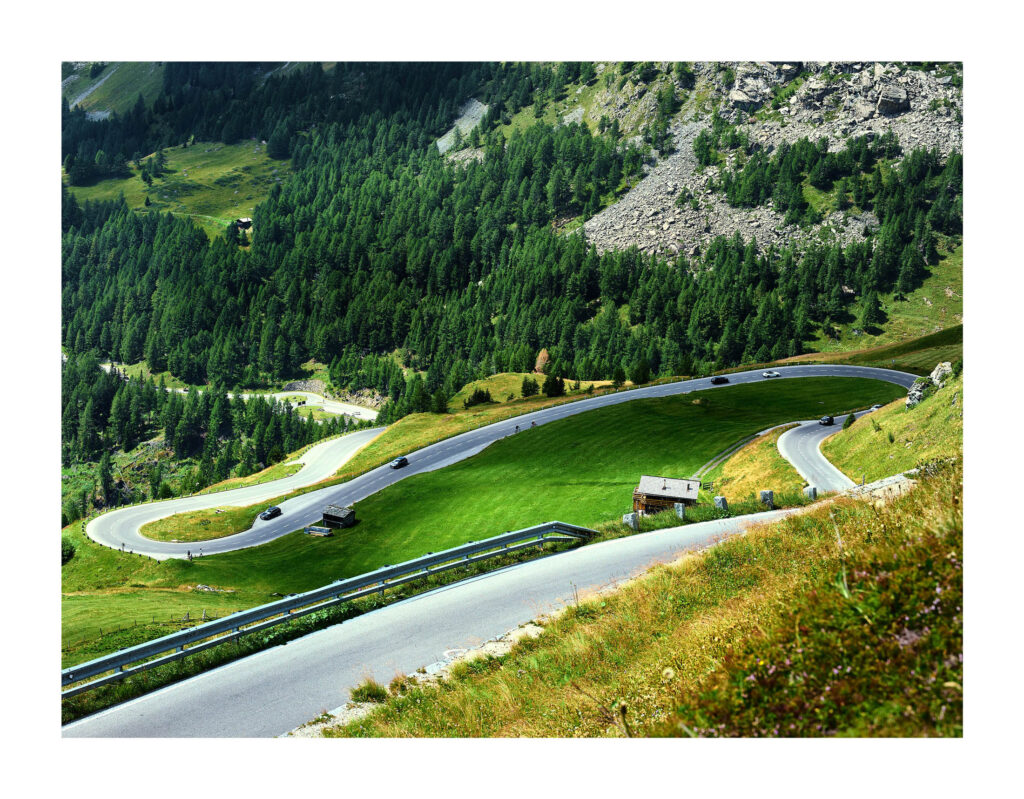 Kurvenreiche Hochalpenstraße durch Wälder und Felsen – professionelle Alpenlandschaftsfotografie von Atelier Schulte