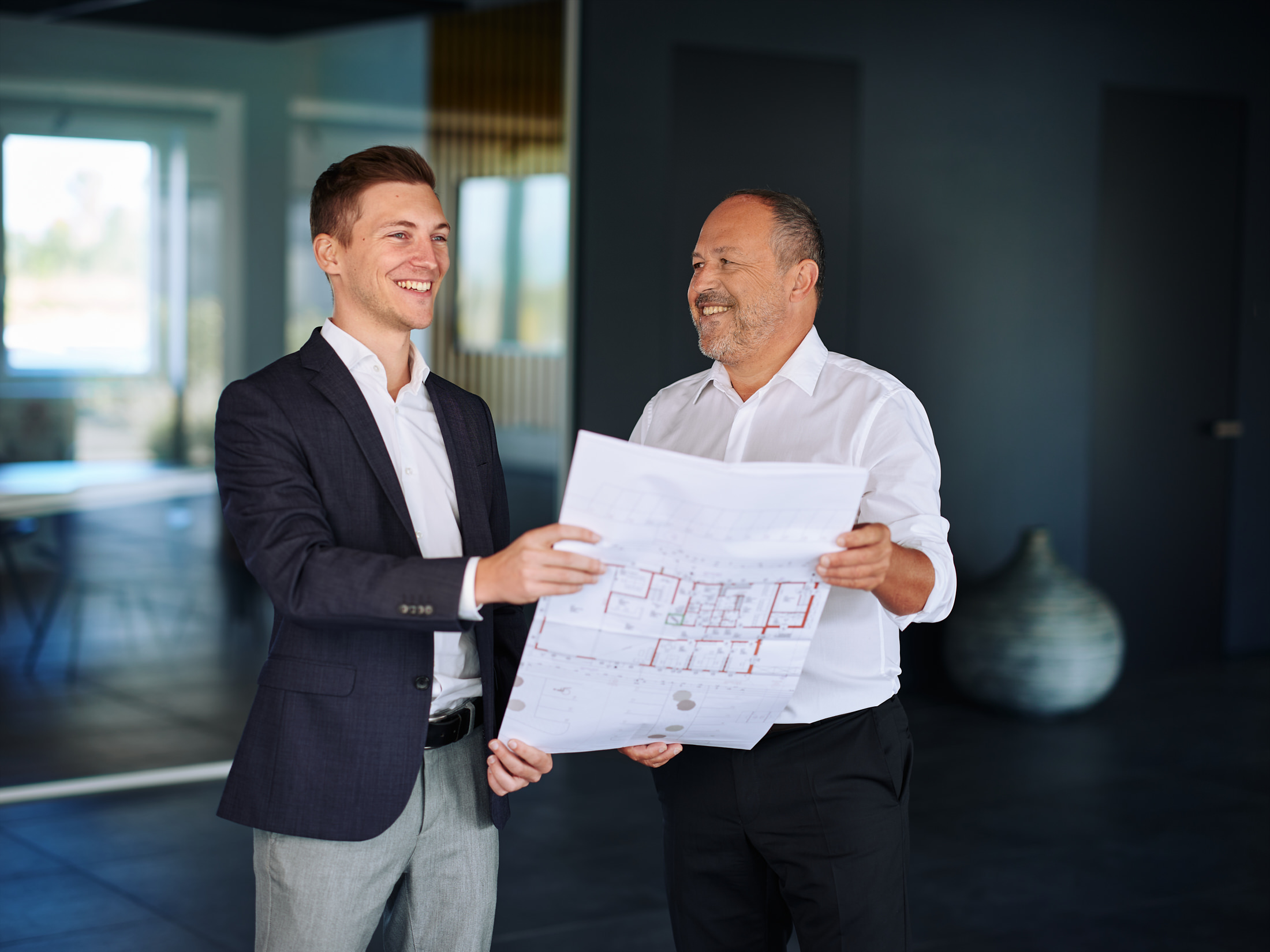 Businessportrait im Konzepthaus – Unternehmer im Gespräch über Architekturpläne fotografiert von Atelier Schulte