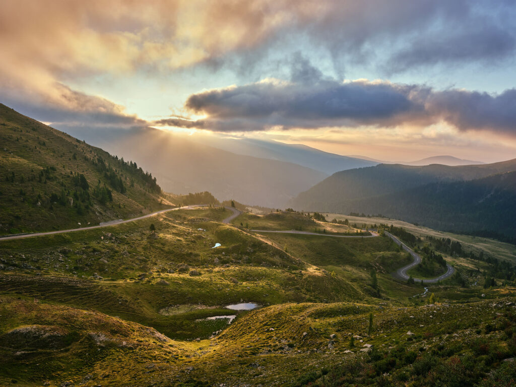 Sonnenstrahlen brechen über den Bergen der Nockalmstraße in Kärnten – stimmungsvolle Landschaftsfotografie von Atelier Schulte, Fotograf Florian Schulte, österreichweit und über die Grenzen hinaus.