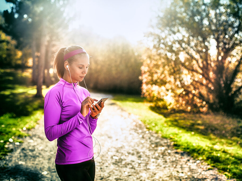 Frau beim Lauftraining im Park, herbstliche Stimmung und Sonnenstrahlen – professionelle Outdoorfotografie von Atelier Schulte.