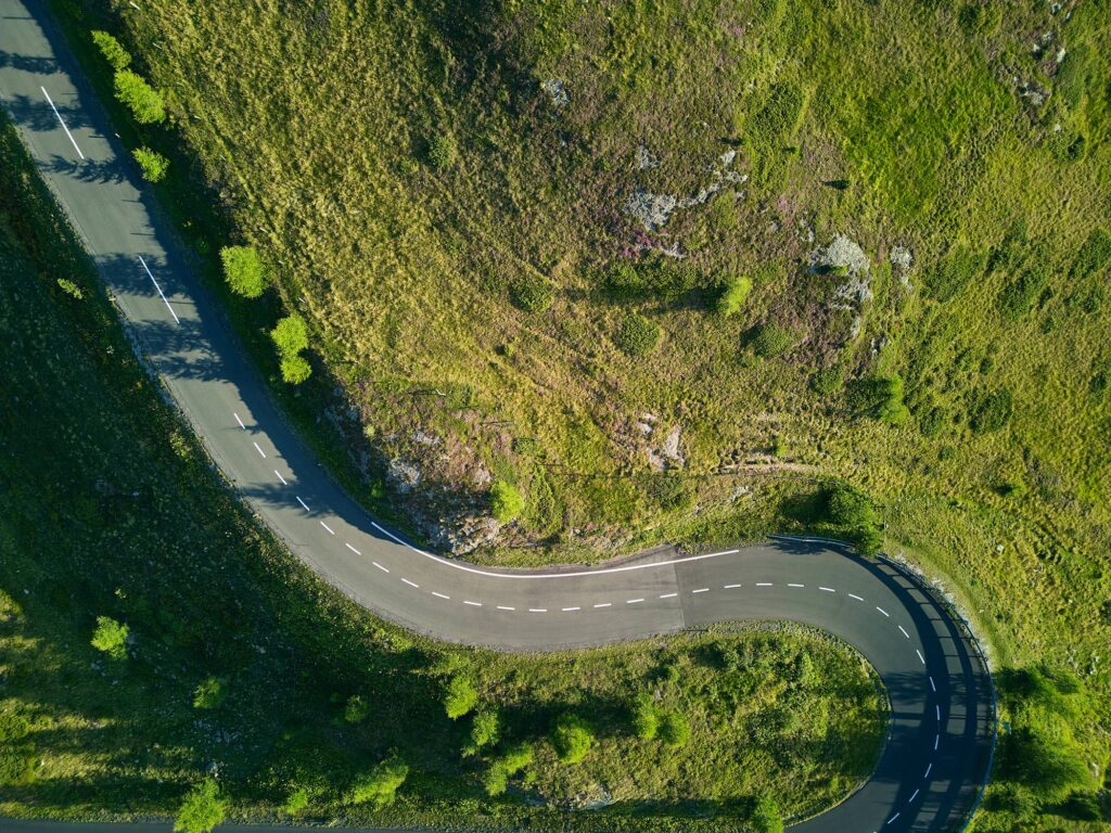 Drohnenaufnahme einer Kurve der Nockalmstraße in den Kärntner Nockbergen – moderne Landschaftsfotografie von Atelier Schulte, Fotograf Florian Schulte, österreichweit und über die Grenzen hinaus.