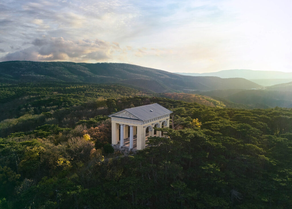 Drohnenaufnahme des Husarentempels in der Abendstimmung, umgeben von bewaldeten Hügeln – professionelle Landschafts- und Architekturfotografie von Atelier Schulte