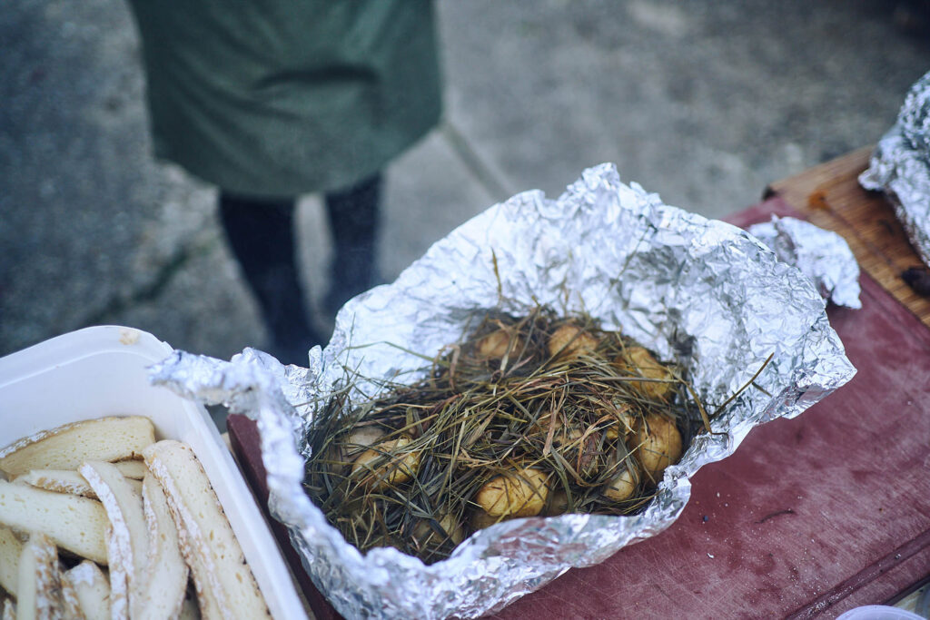 Ofenkartoffeln im Heu gegart, in Alufolie serviert bei Essen vor Ort am Wagram in Niederösterreich. Reportagefotografie mit handwerklichem Charakter, Atelier Schulte.