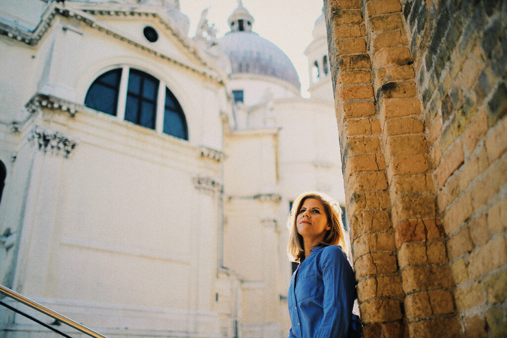 Portraitfotografie Workshop Venedig – natürliches Outdoor-Portrait einer Frau im warmen Licht vor historischer Architektur.
