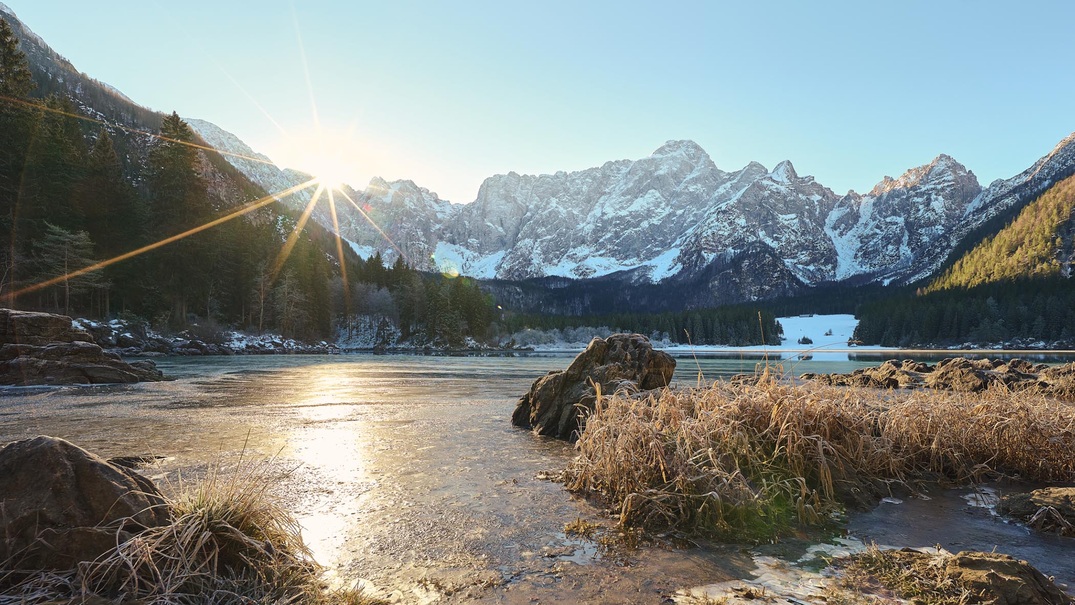 Sonnenaufgang am Lago di Fusine im Winter, Eisflächen, Bergkamm und klares Morgenlicht – Landschaftsfotograf Florian Schulte