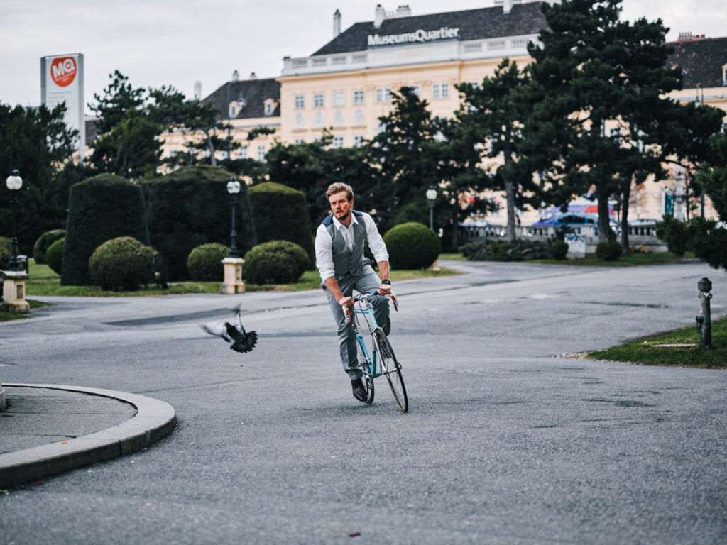 Mann mit Fahrrad im Wiener Stadtraum – urbane Lifestyle-Fotografie mit Bewegung, Freiheit und moderner Ästhetik