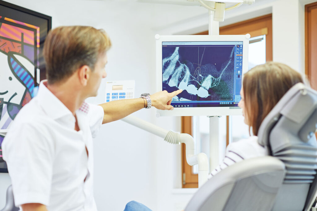 Zahnarzt erklärt Diagnose am Monitor – professionelle Praxisfotografie für Transparenz und Vertrauen im Gesundheitswesen