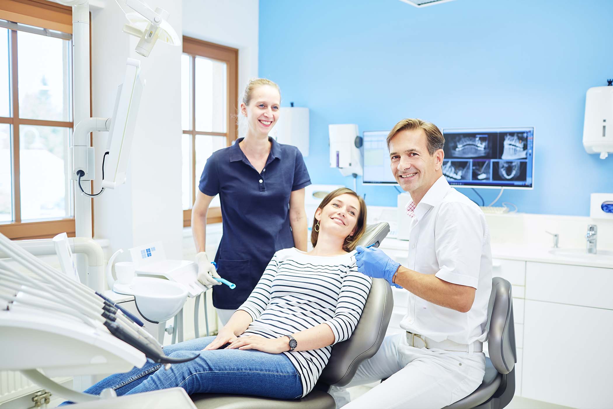 Zahnarzt mit Team und Patientin in moderner Ordination – authentische Praxisfotografie für Vertrauen im Gesudheitswesen