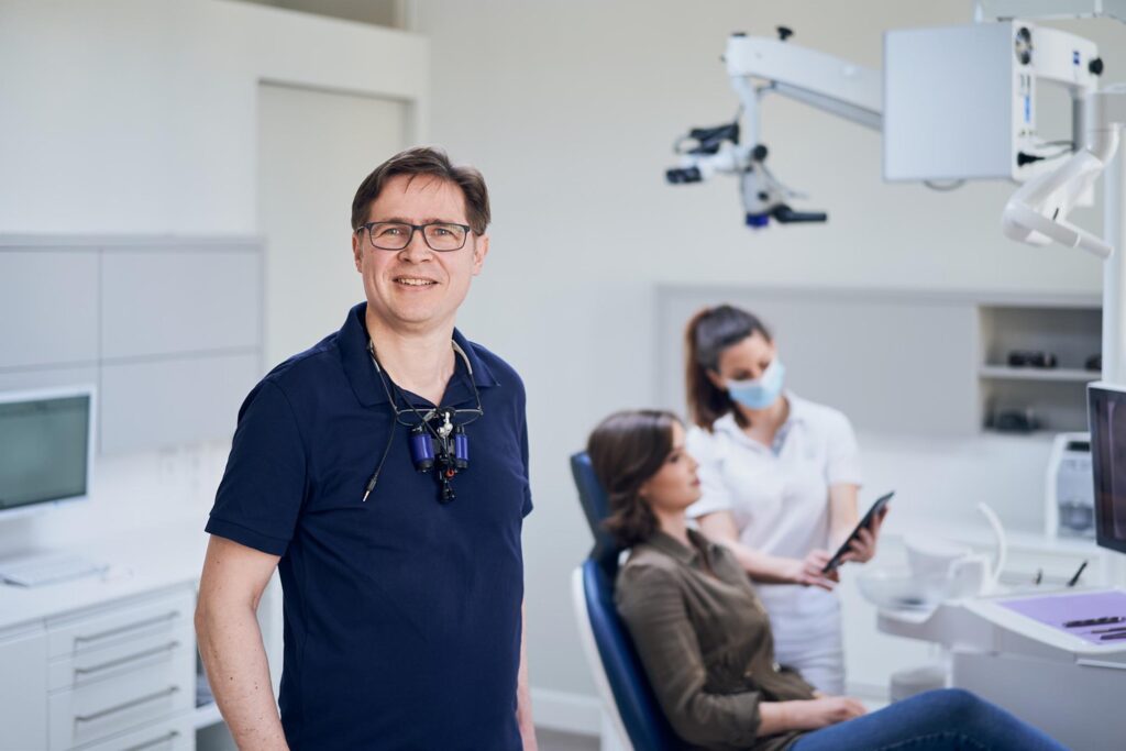 Zahnarzt und Assistenzteam bei einer Behandlung in moderner Zahnarztpraxis in Wien.