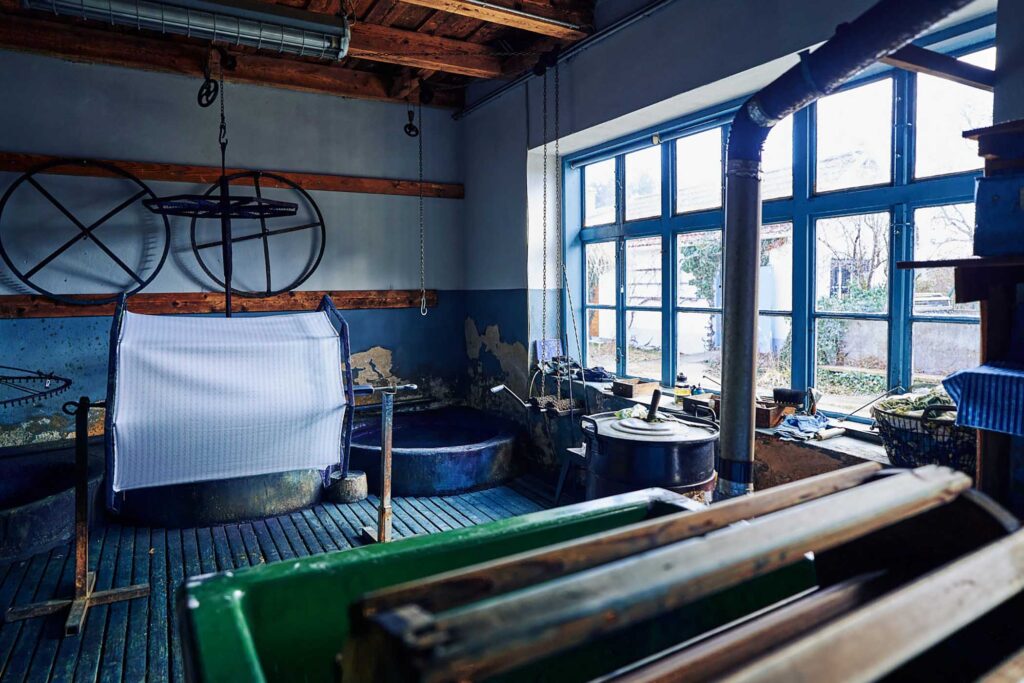 Werkstattbereich einer historischen Blaudruckerei im Burgenland mit Färbebottichen und Arbeitsgeräten – Reportagefotografie von Florian Schulte.