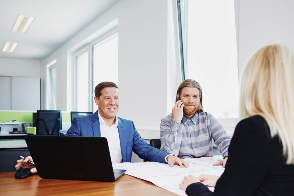 Business-Fotoshooting für Unternehmen in Österreich: Mitarbeitende in einer Besprechung, fotografiert im Arbeitsalltag für Unternehmenskommunikation