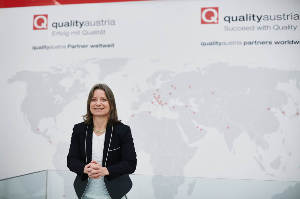 Professionelles Businessportrait eines CEO in im Unternehmensumfeld vor internationaler Standortkarte – fotografiert für Unternehmenskommunikation in Österreich