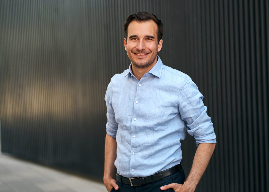 Professionelles Businessportrait eines Mitarbeiters vor moderner Architektur – fotografiert im Rahmen eines strukturierten Business-Fotoshootings in Österreich