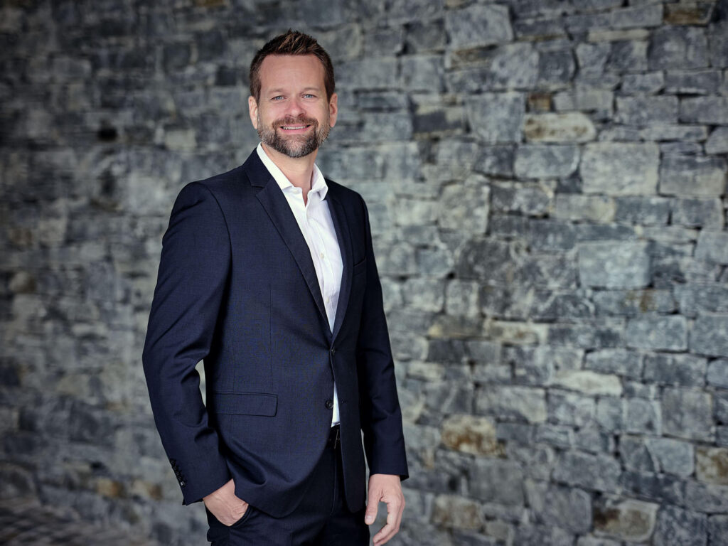 Businessportrait eines Managers vor Steinwand – professionelle Businessfotografie in Österreich, Atelier Schulte