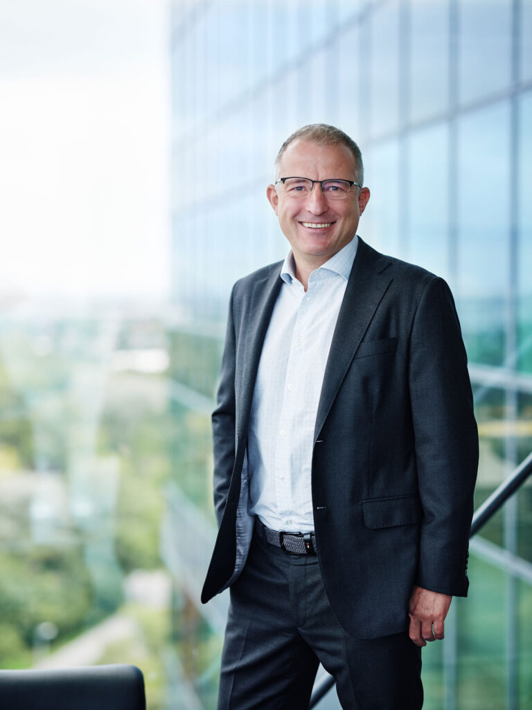 Businessportrait eines Managers vor moderner Glasarchitektur – professionelle Businessfotografie in Österreich, Atelier Schulte.
