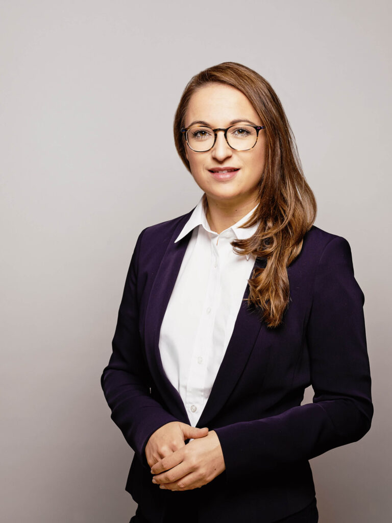 Businessportrait einer Mitarbeiterin vor neutralem Hintergrund – professionelle Businessfotografie in Österreich, Atelier Schulte.