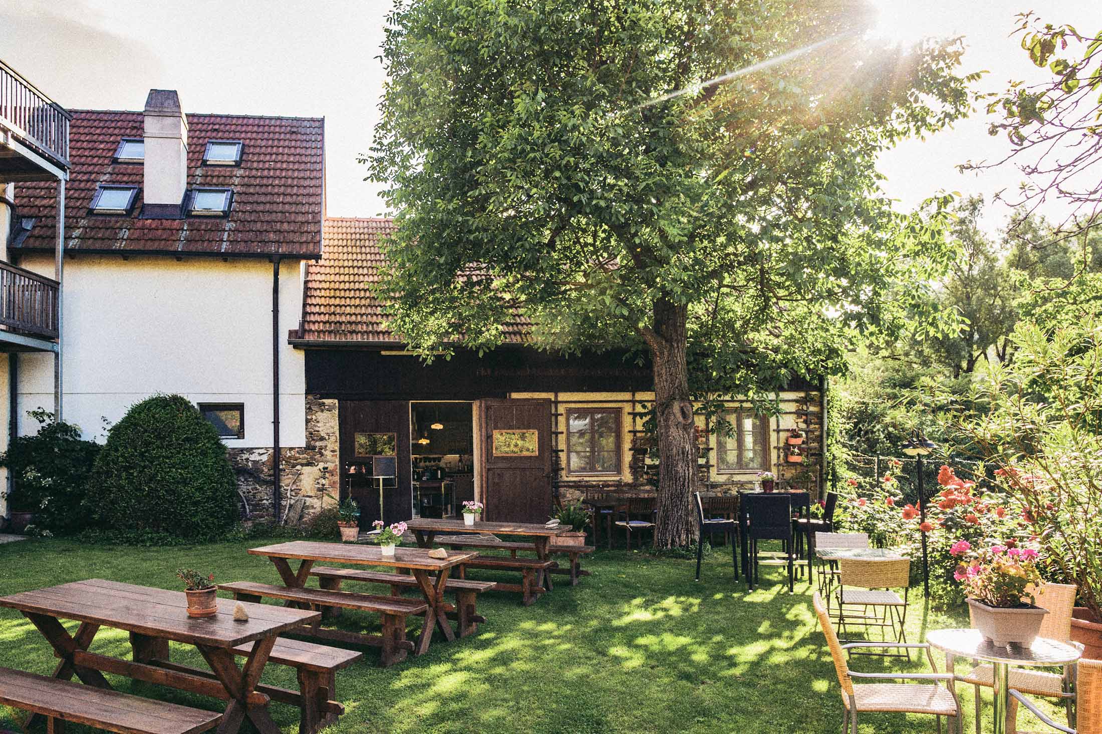 Gastgarten in der Wachau im warmen Abendlicht – Architekturreportage mit Fokus auf Atmosphäre, Gartenmöbeln und sommerlicher Lichtstimmung, fotografiert von Atelier Schulte.