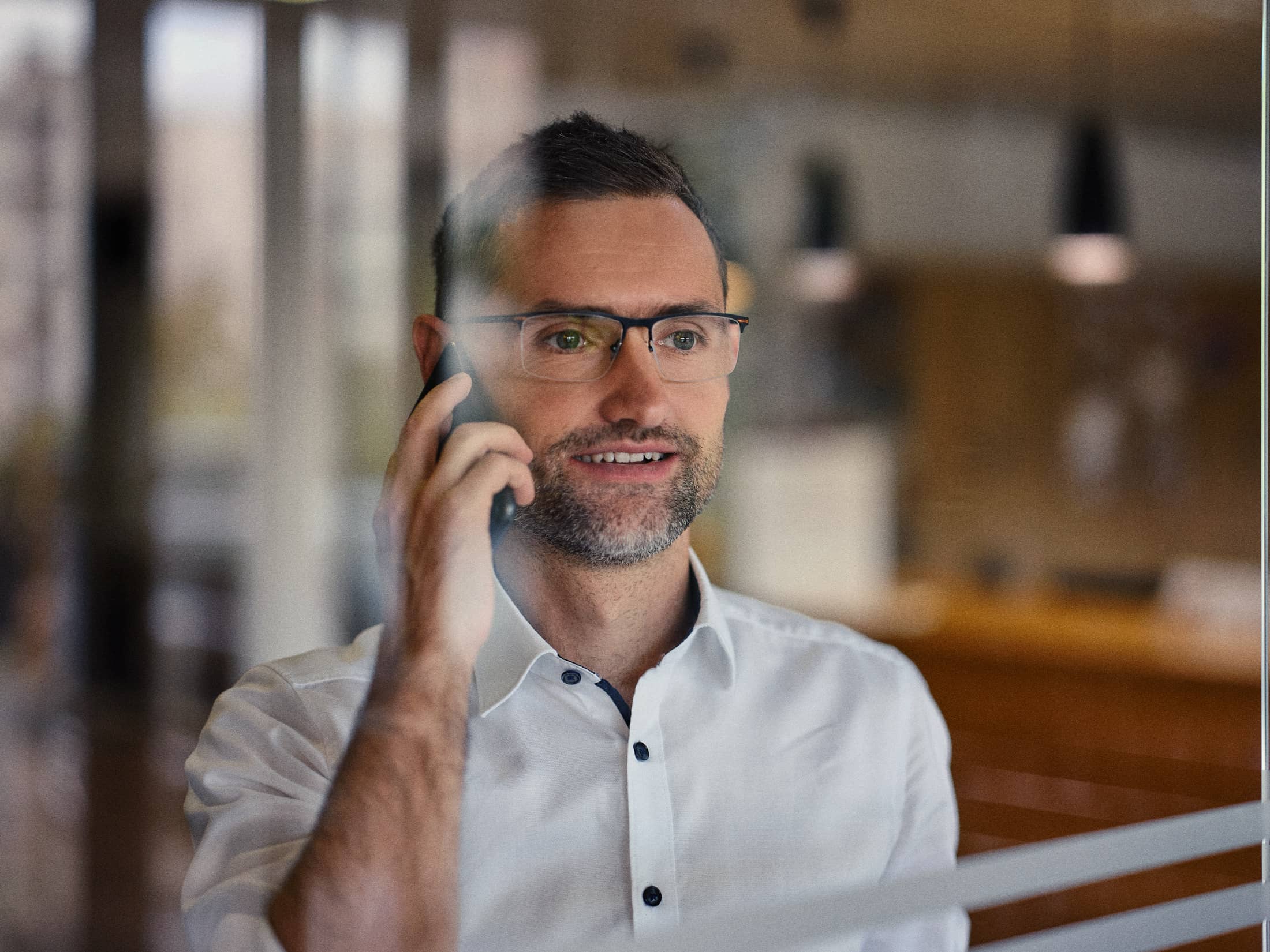 Businessportrait einer Führungskraft im Büro in Österreich – ruhige, konzentrierte Darstellung während eines Telefonats, klare und präzise Bildsprache, fotografiert von Florian Schulte