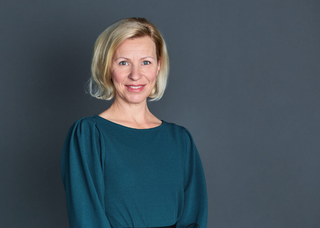 Professionelles Businessportrait einer Mitarbeiterin vor neutralem Hintergrund – Beispiel für authentische Mitarbeiterfotos und relevante Kostenfaktoren in der Businessfotografie für Unternehmen.