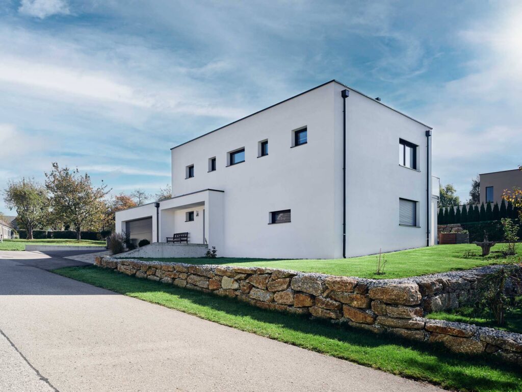 Moderne Einfamilienhaus-Architektur in Österreich, fotografiert auf Augenhöhe mit klarer Fassadenstruktur, präzisen Proportionen und natürlicher Lichtführung – Architekturfotografie von Atelier Schulte