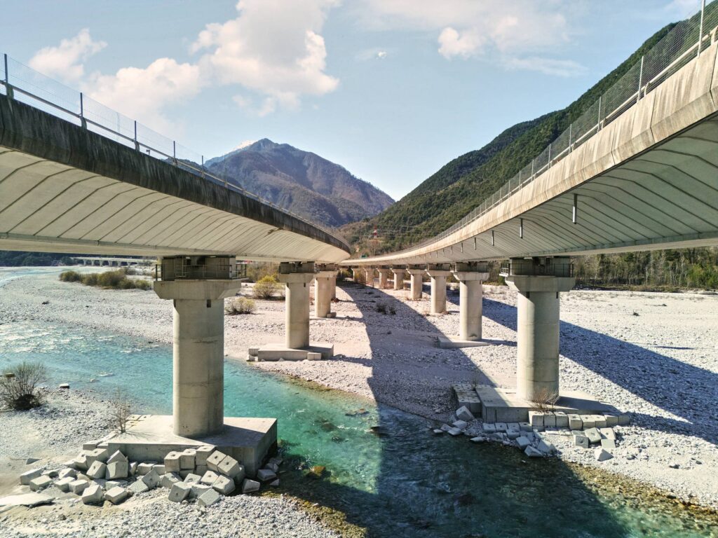 Brückenkonstruktion als strukturierender Raum über einem Fluss mit Licht und Schatten