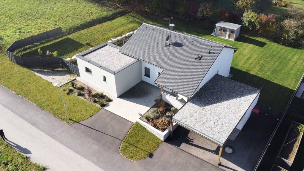Drohnenaufnahme eines Einfamilienhauses in Österreich mit Grundstück, Zufahrt und Umgebung – typische Perspektive der Immobilienfotografie