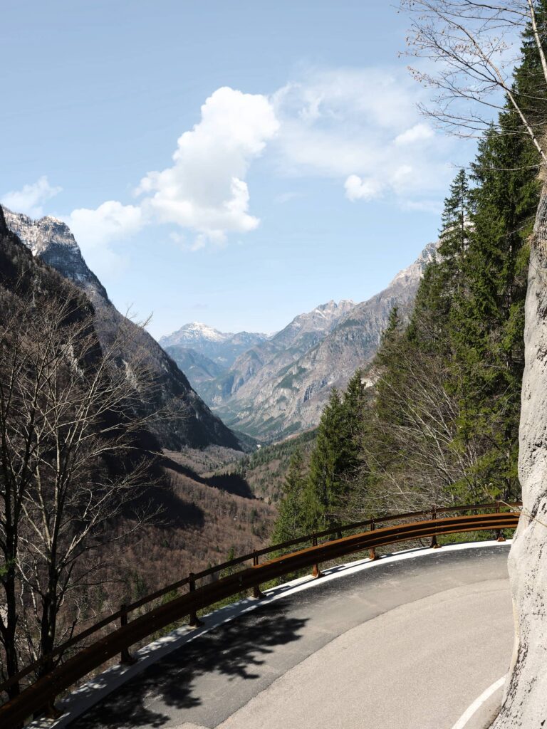 Serpentinenstraße mit Leitplanke in alpiner Berglandschaft mit Blick ins Tal