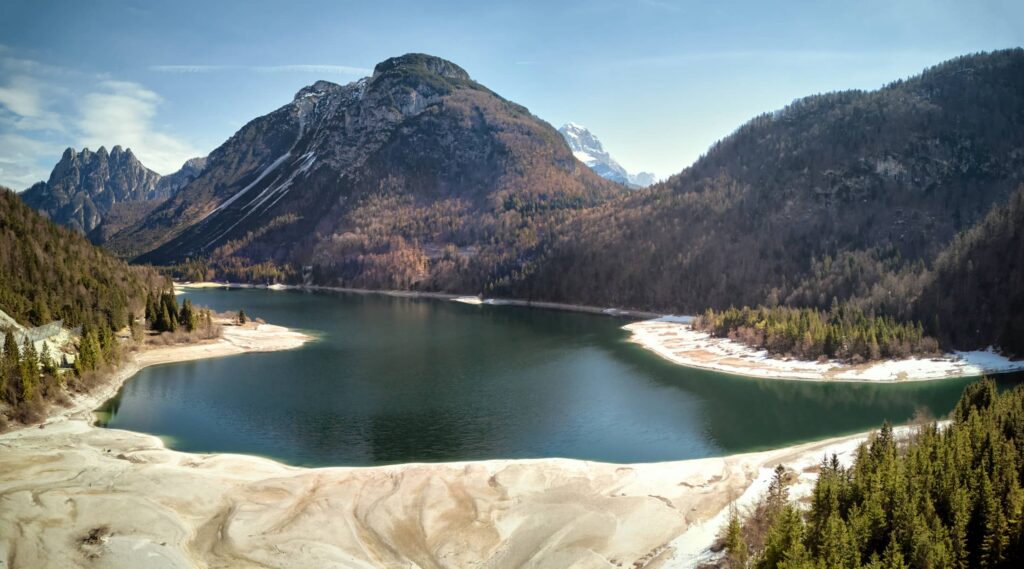 Alpine Landschaft mit Bergsee, schneebedeckten Ufern und ruhigen Lichtstimmungen im Alpen-Adria-Raum – professionelle Landschaftsfotografie von Atelier Schulte mit natürlicher Atmosphäre und klarer Bildwirkung.