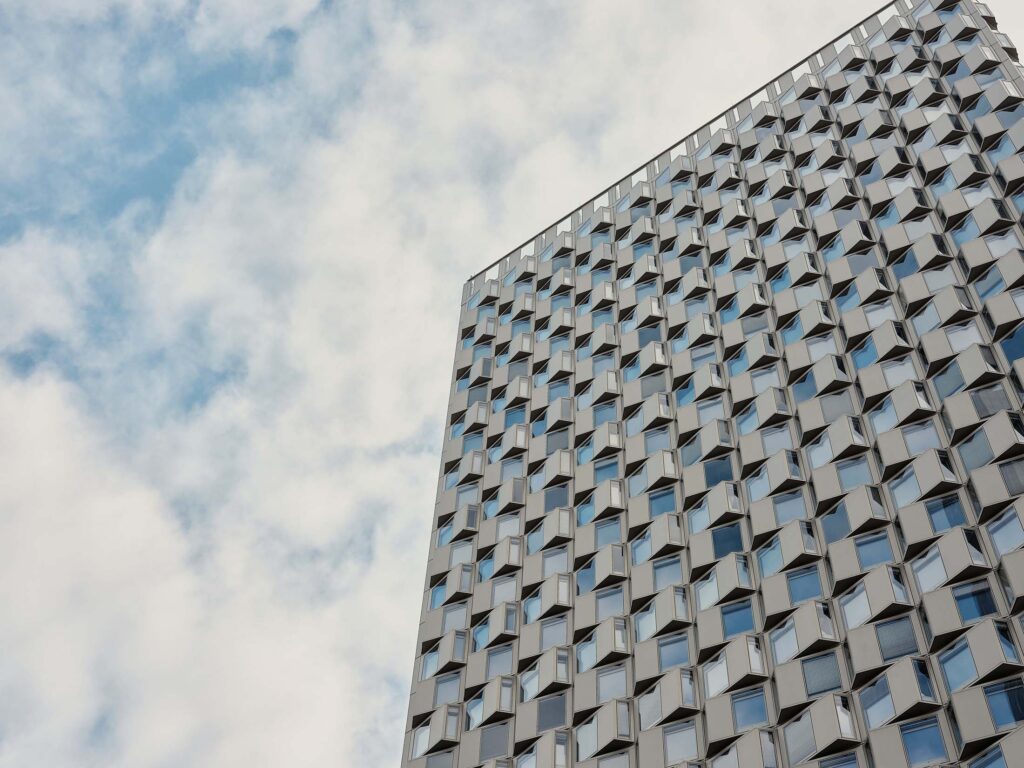 Moderne Fassade mit rhythmisch angeordneten Fensterelementen in Wien, fotografiert mit klarer Perspektive und ruhigem Licht im urbanen Raum.