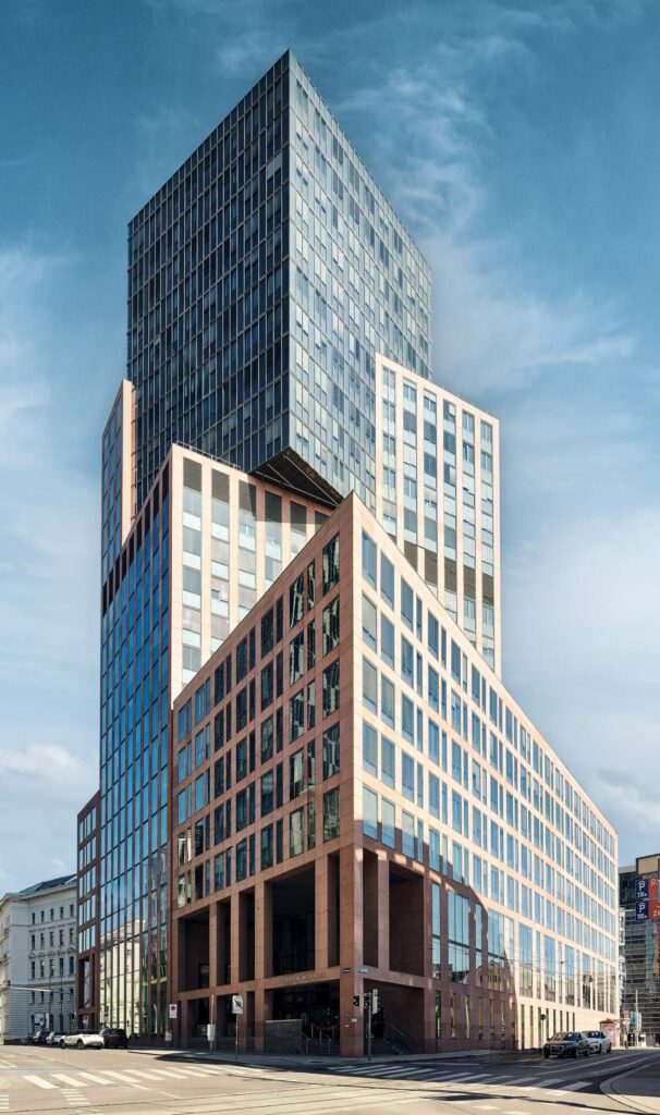 Moderner Hochbau in Wien mit markanter Staffelung und klarer Linienführung, fotografiert bei ruhigem Licht im urbanen Stadtraum.